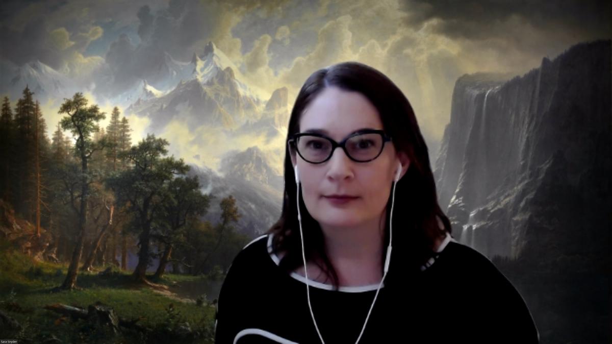 A photo of a woman in front of an artwork