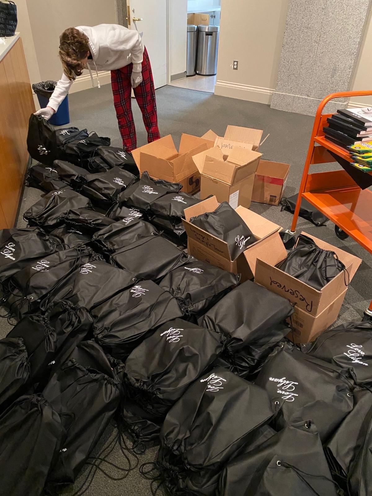 A teenager sorting through backpacks. 