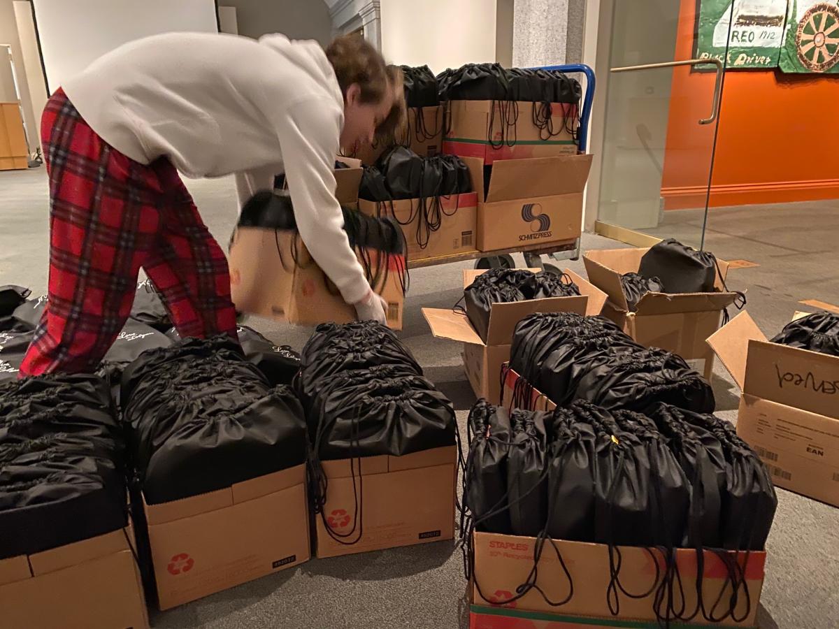 A teenage boy packing backpacks
