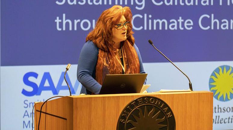 A woman standing by a podium