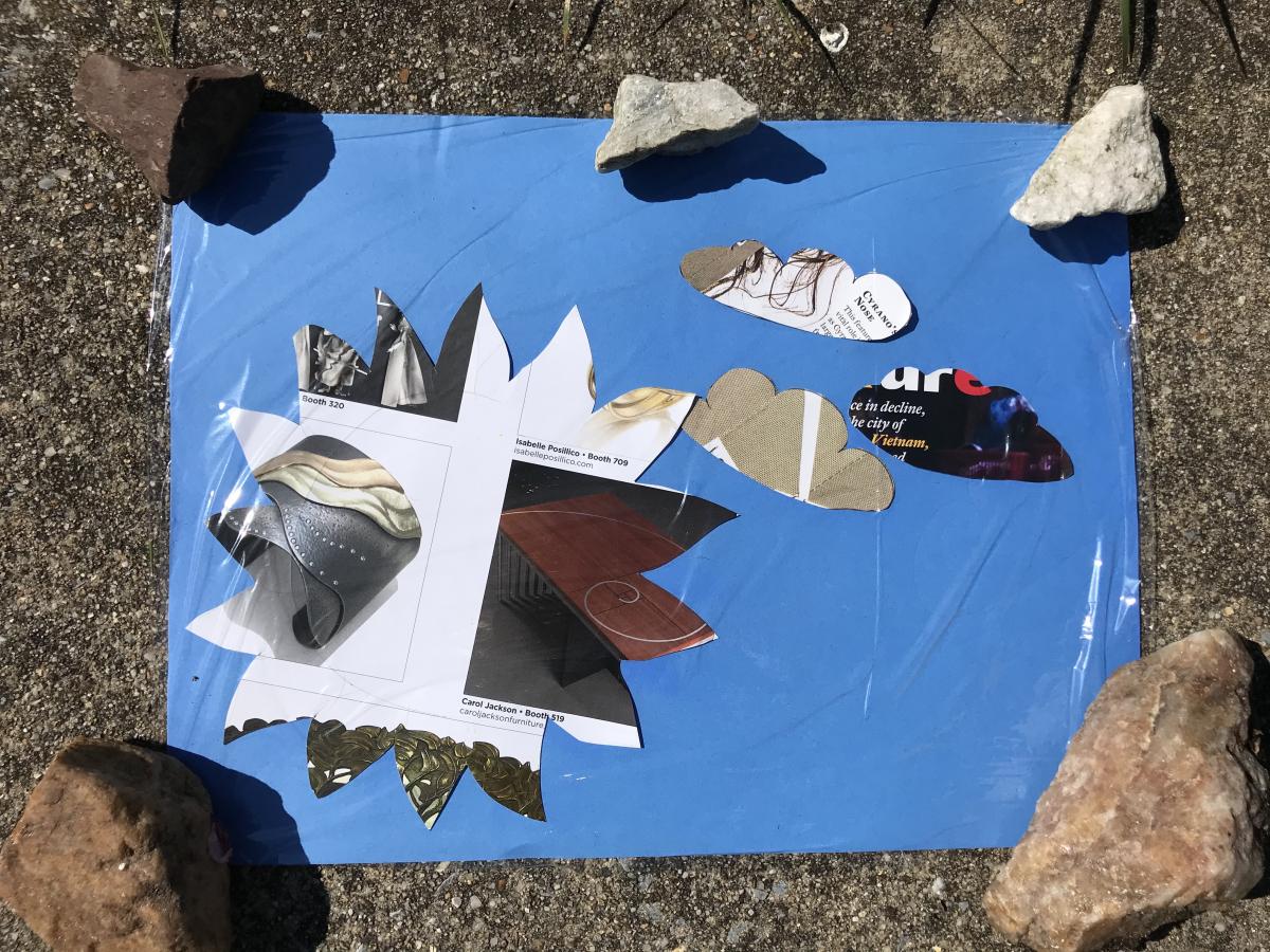 A photo of shapes cut out on a piece of paper with rocks holding it down.