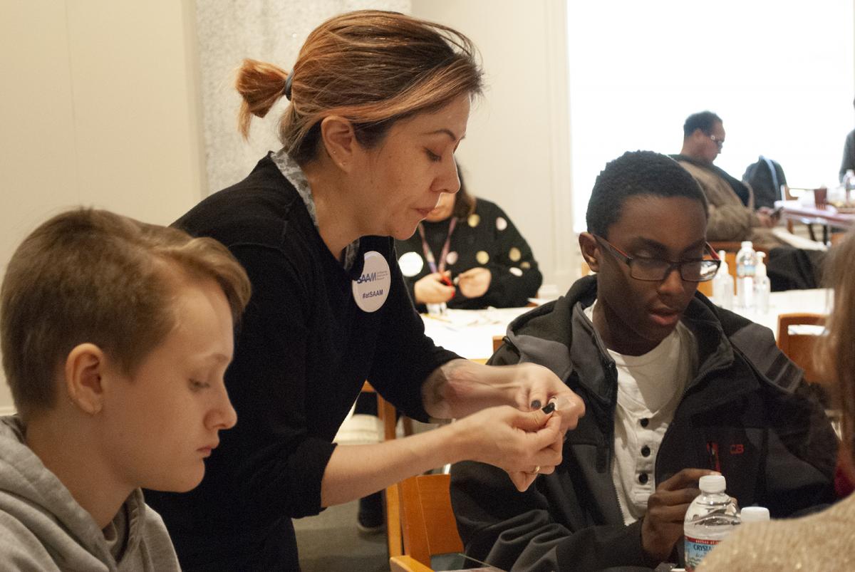 A photograph of teenagers interacting with an adult