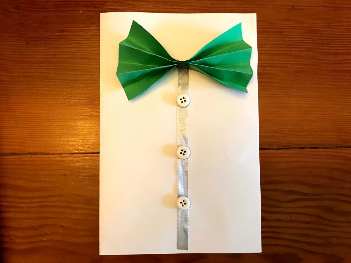 A photograph of a handmade card with a bowtie