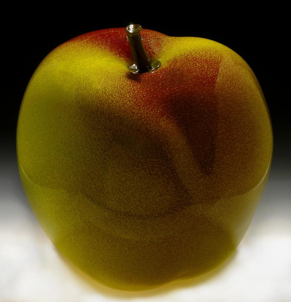 A photograph of a large apple made of glass.