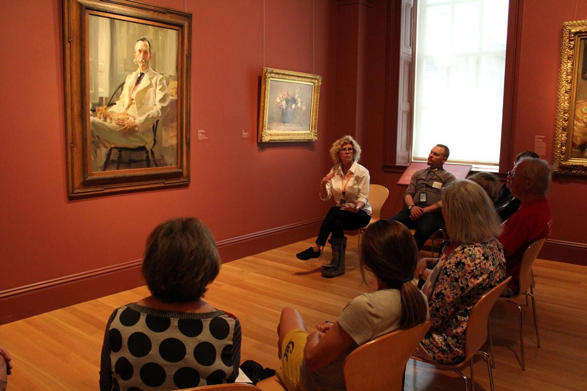 A photograph of a group in an art gallery in conversation. 