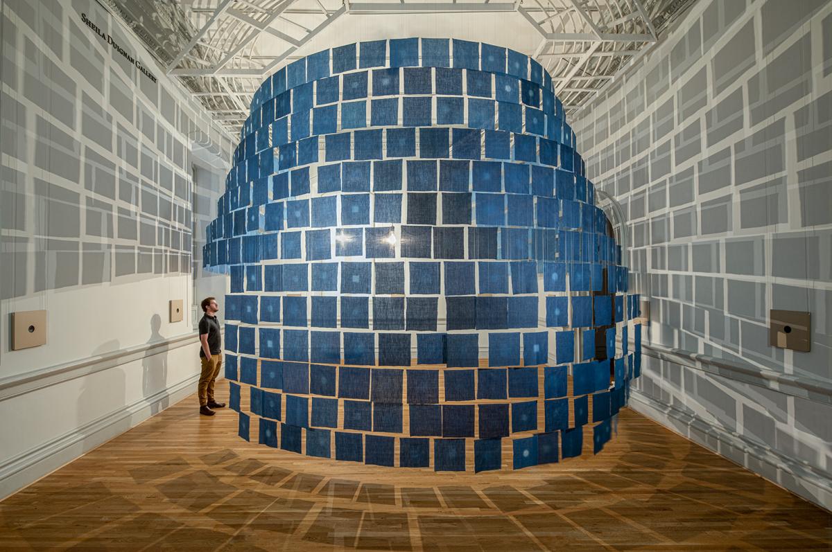 An installation with small indigo cloths hanging from the ceiling. 