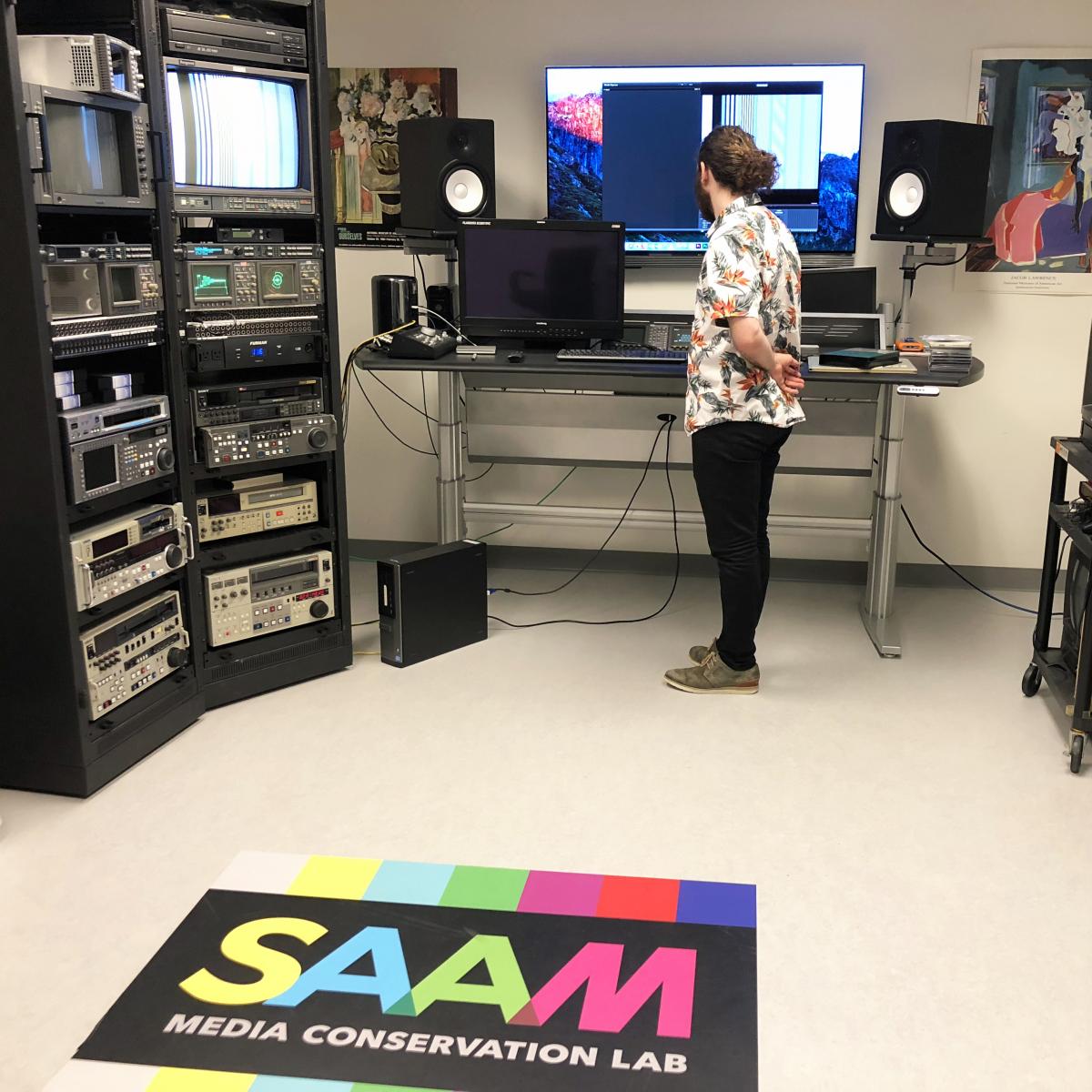 A man standing inside a lab of computers