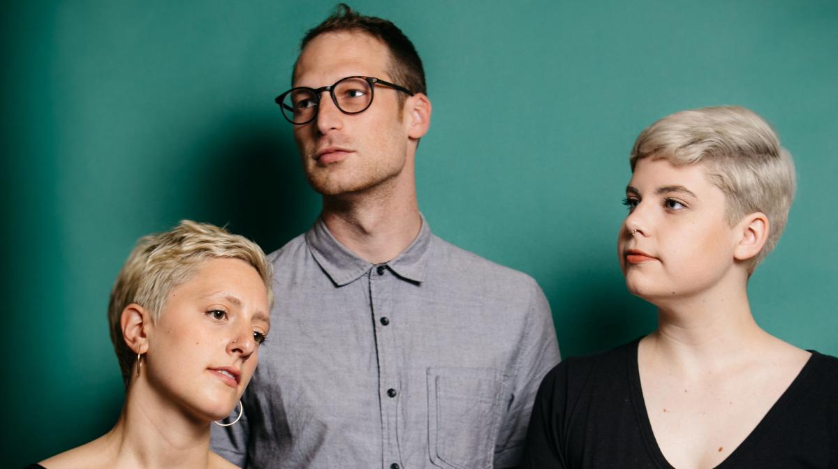 A photograph of three people standing next to each other.