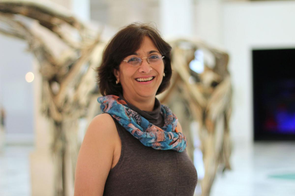 A photograph of a woman inside an art gallery. 