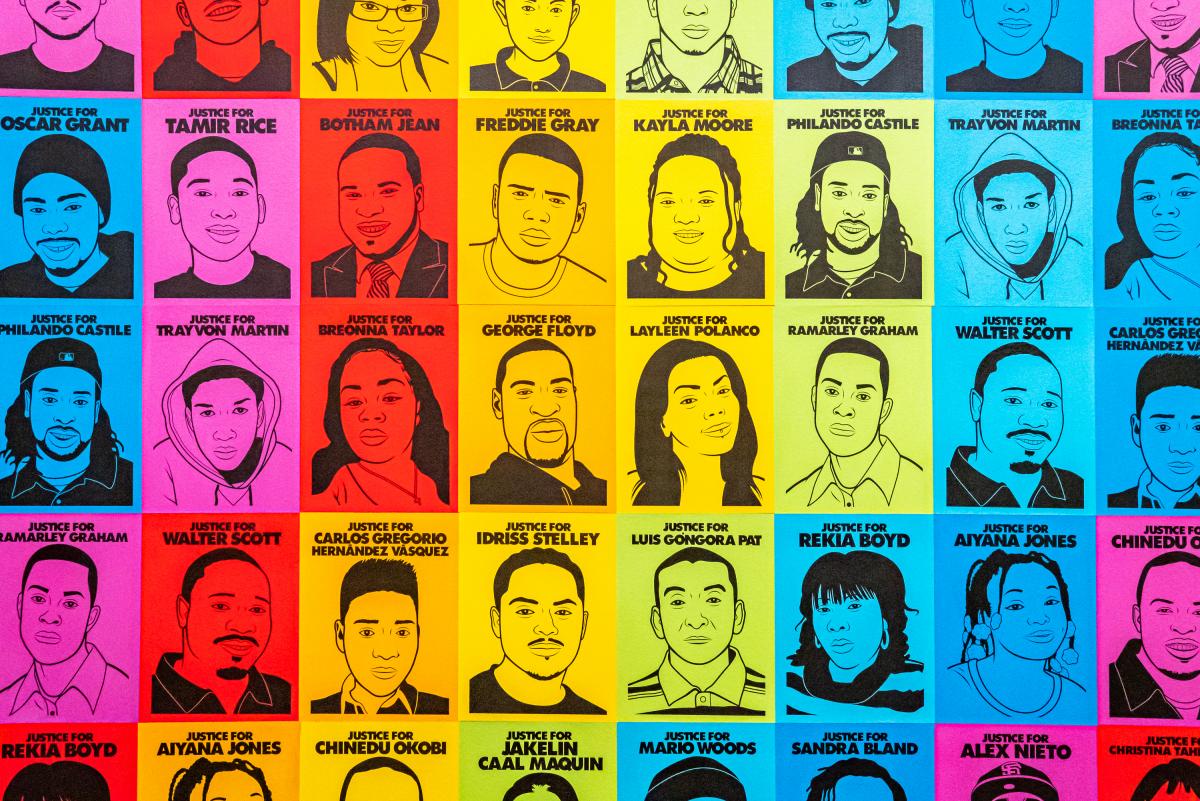 A photograph of an artwork with many different faces. 