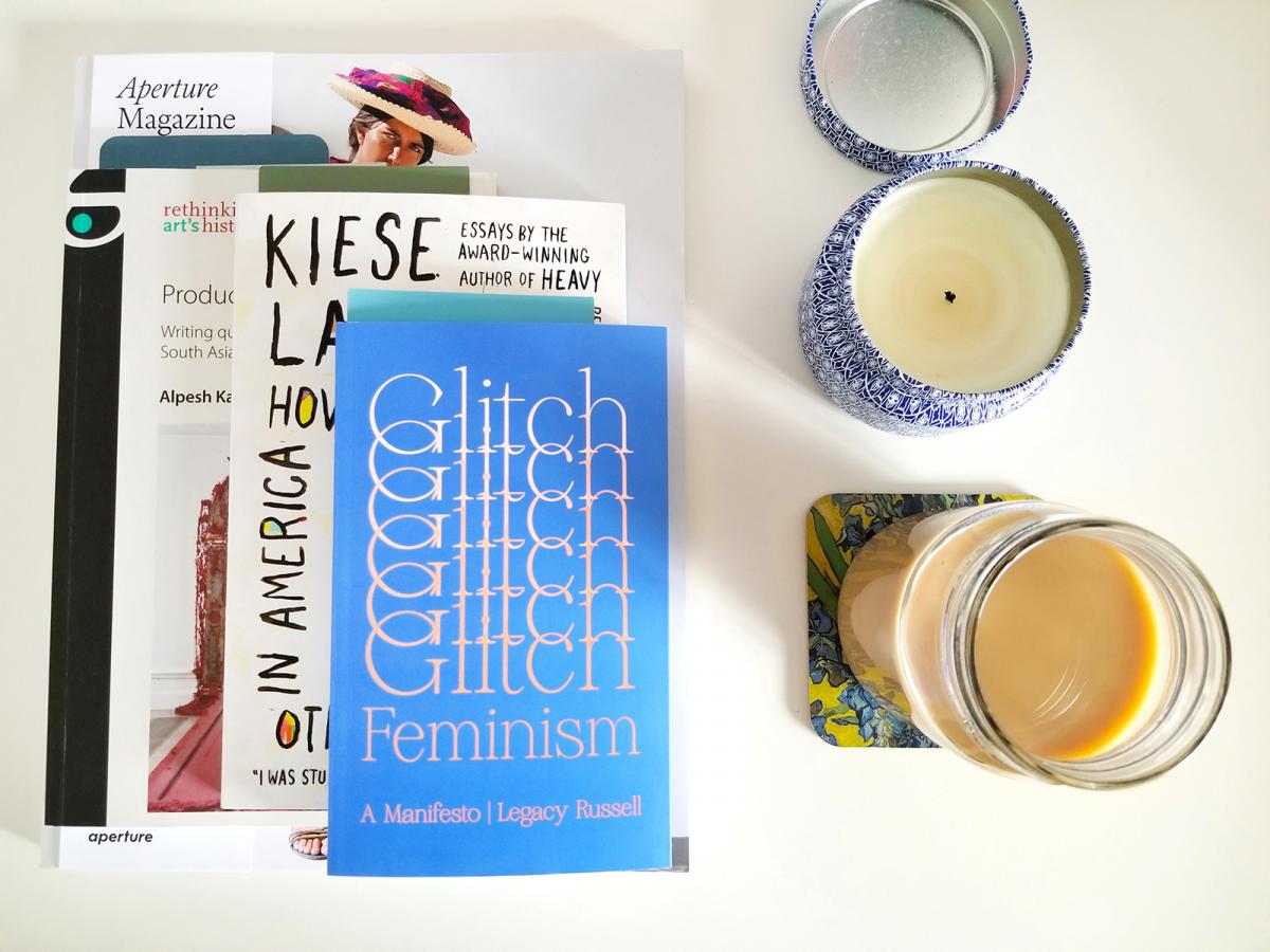 A photograph of books on a table with candles
