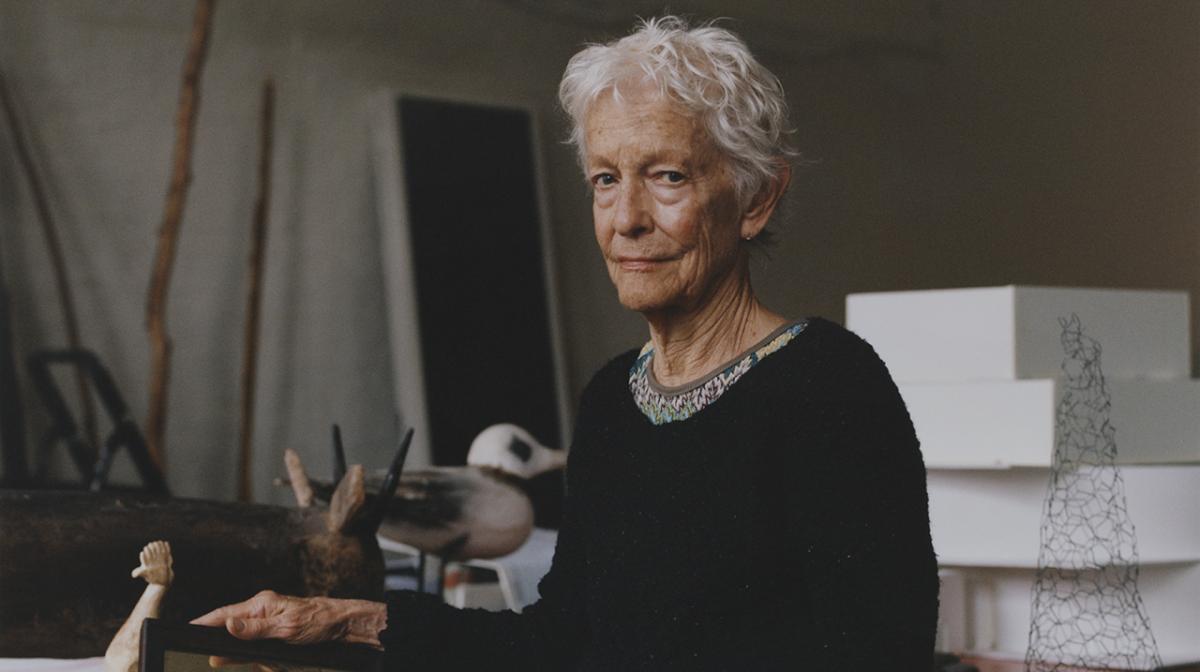 A photograph of a woman sitting in a studio.