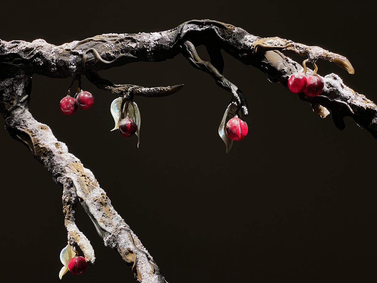 An installation photograph of a tree made of glass with red balls