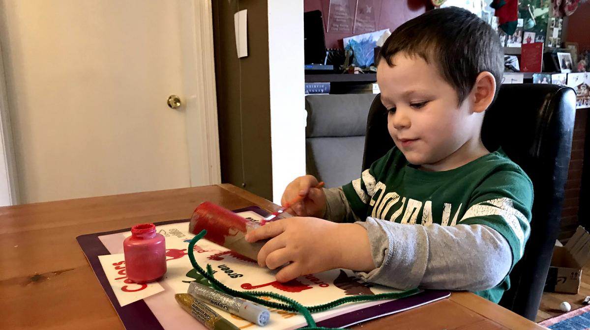 A photograph of a child making crafts at a table
