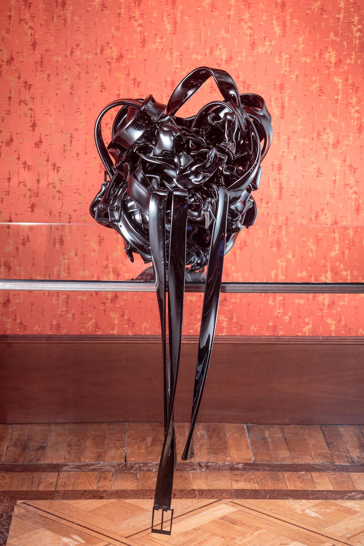 An artwork image of a black object that turns into a belt. 