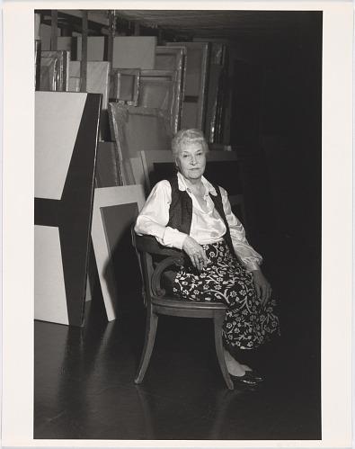 A white haired woman sitting in a chair.