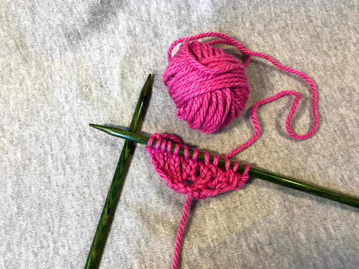 Knitting a cherry blossom petal in pink yarn