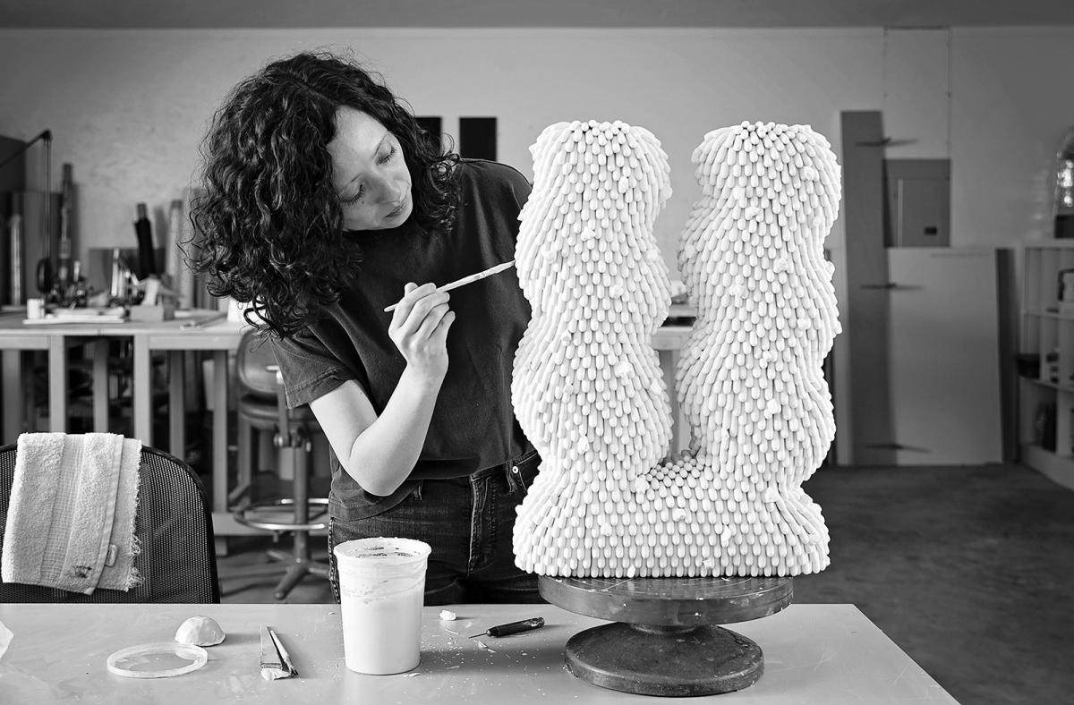 A photograph of an artist in her studio