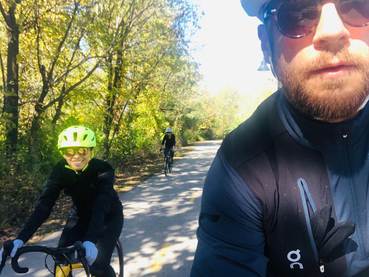 A photograph of two people riding a bike