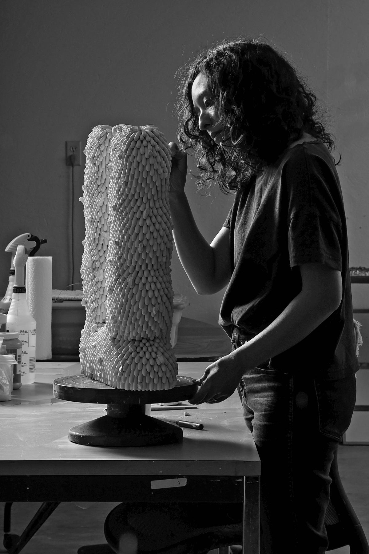 A photograph of an artist in her studio