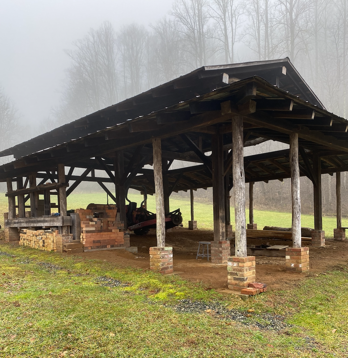 Wooden structure of a roof supported by poles with open sides, covering a kiln