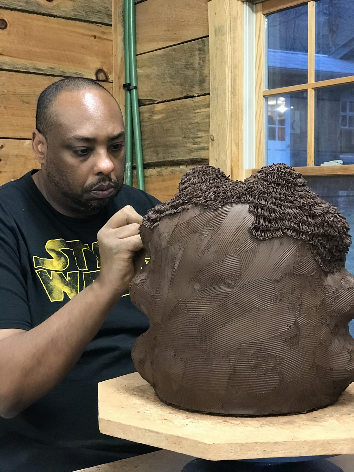 Artist Donté Hayes working in his studio on a sculpture