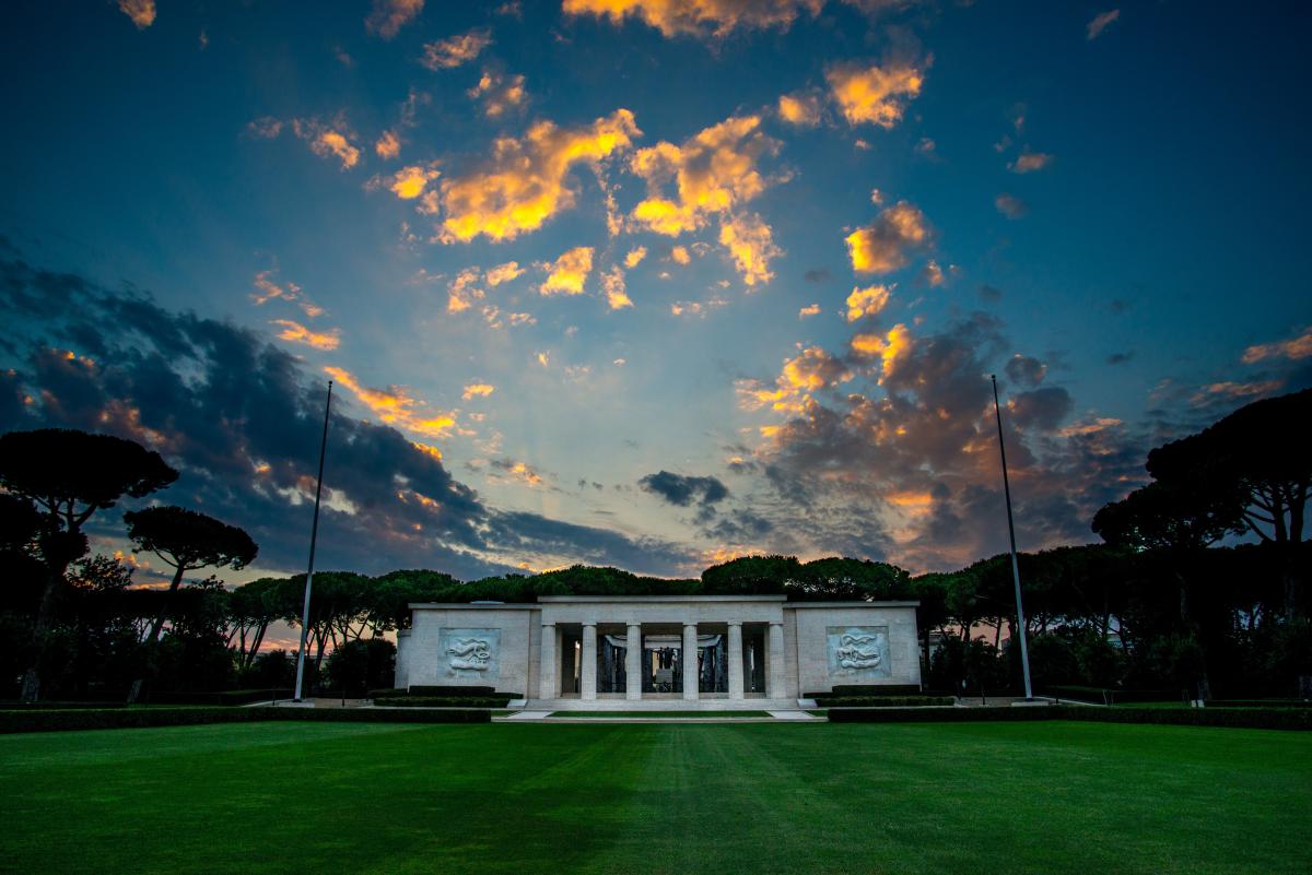 Landscape image of  a cemetery with marble chapel in center. 