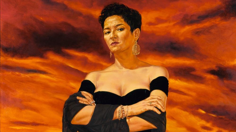 Woman with her arms crossed with a sunset background.