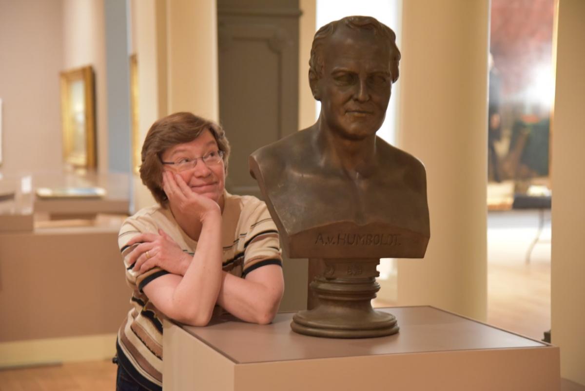 Curator standing next to a bust of Alexander von Humboldt