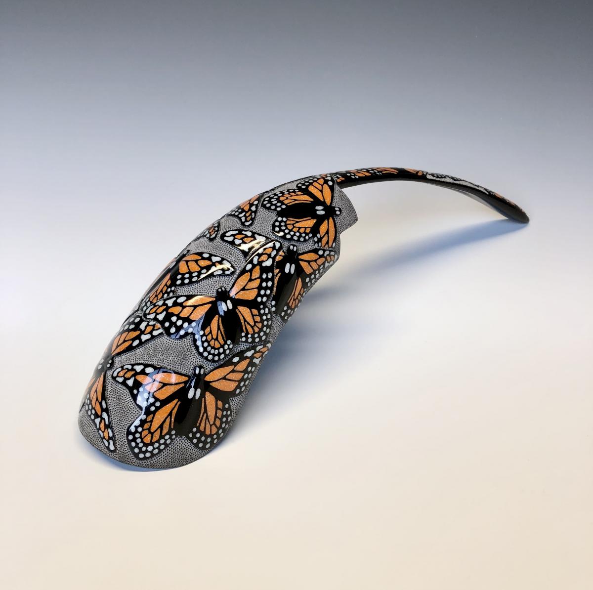Fragment of a buffalo horn painted with orange butterflies on it.