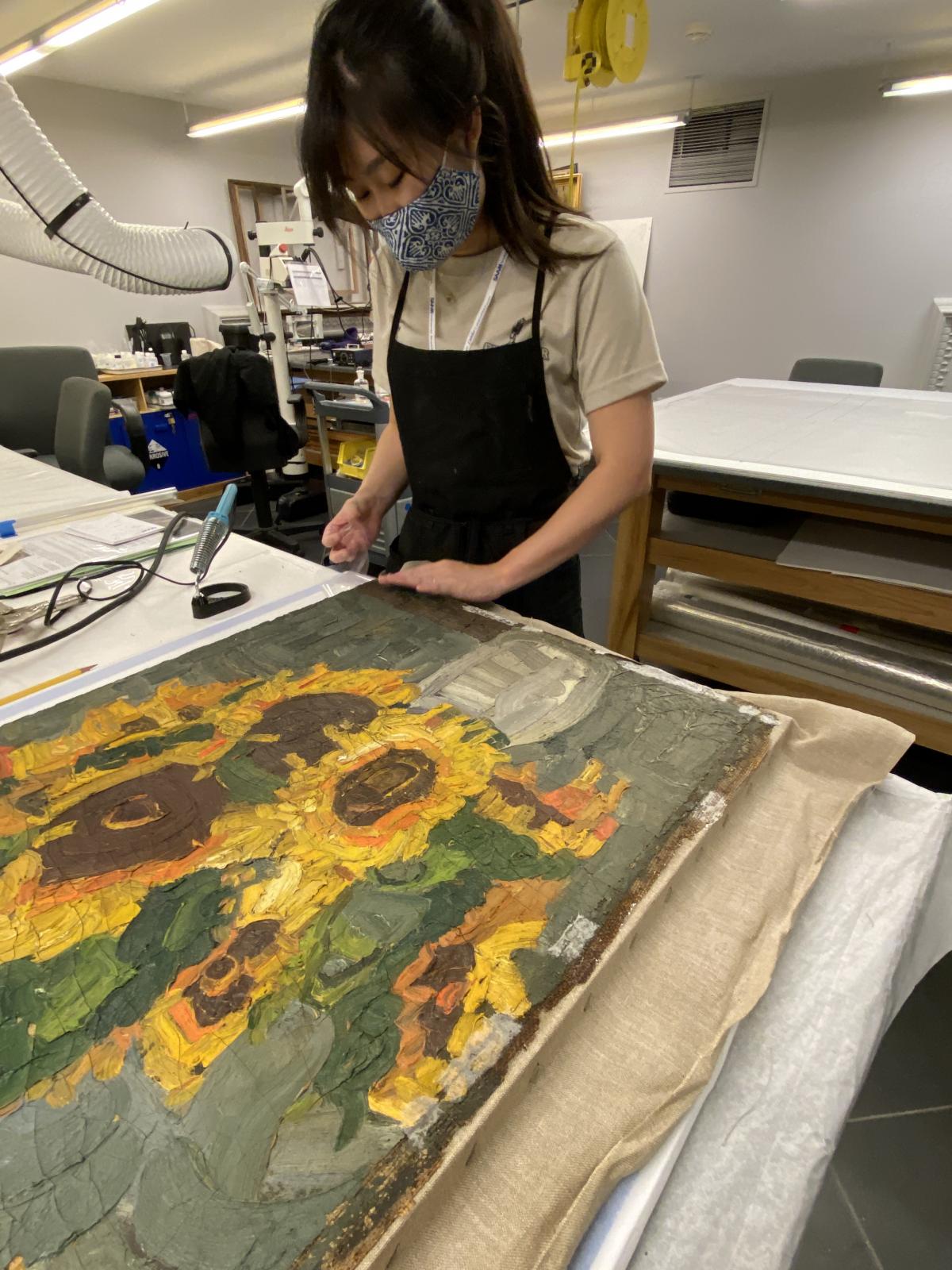 Conservator working on William H. Johnson Sunflowers