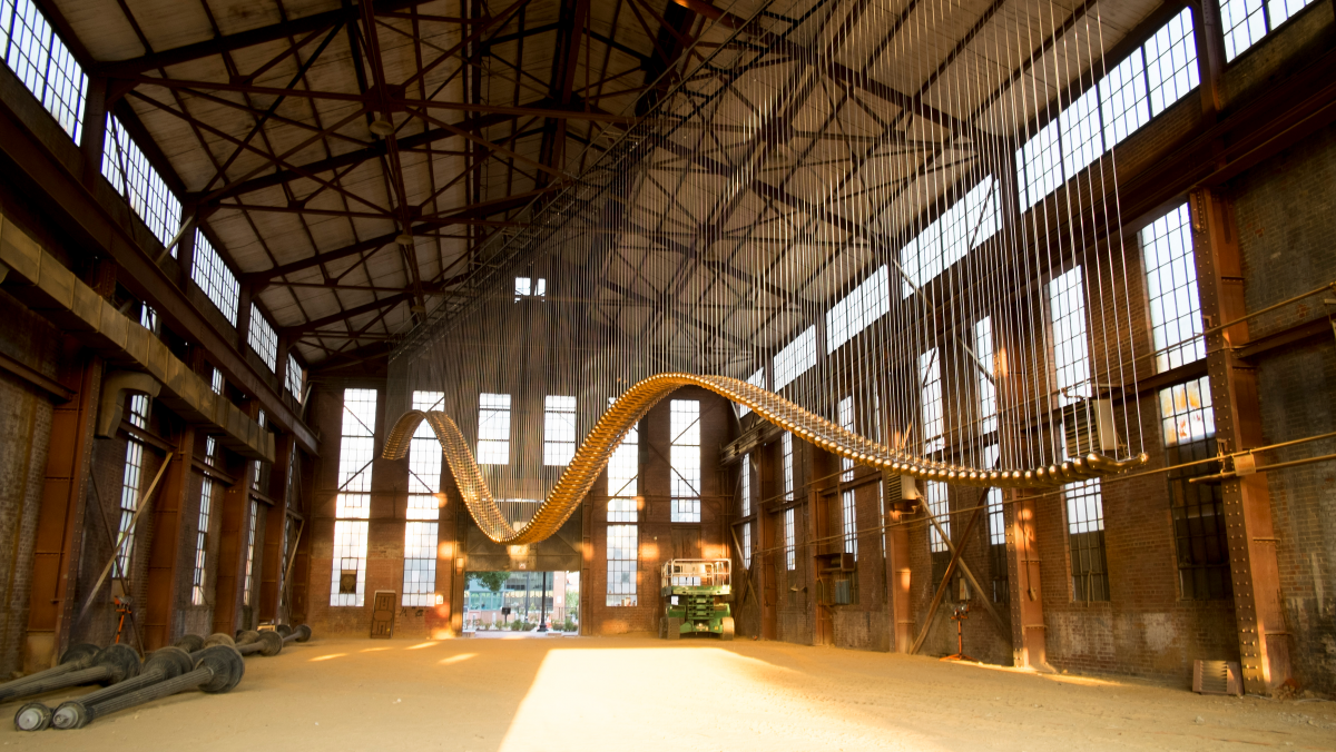A sculpture of fiberglass fists painted gold, connected like a bridge