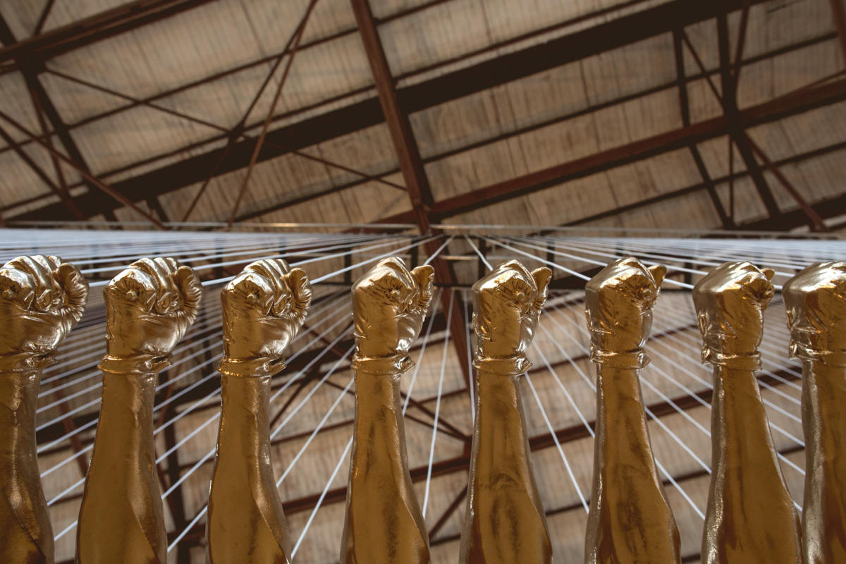 A sculpture of fiberglass fists painted gold, connected like a bridge