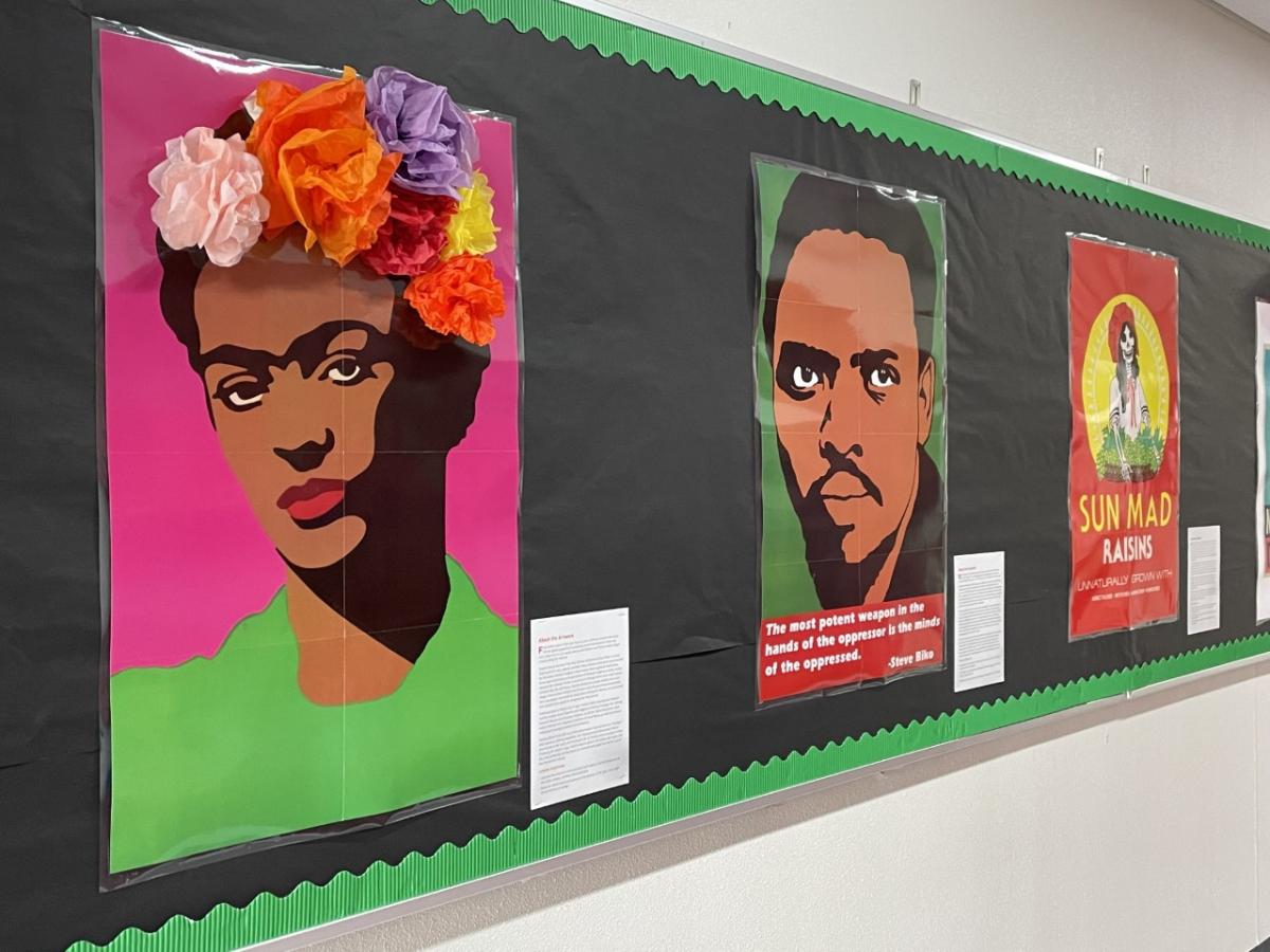 Posters on a school hallway bulletin board. They are decorated with paper flowers