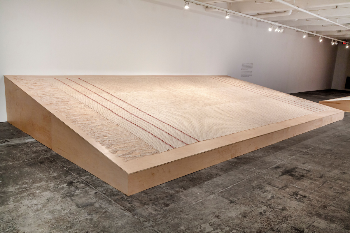 Large scale installation of fabric made of woven linen with madder dye, on a wodden board.