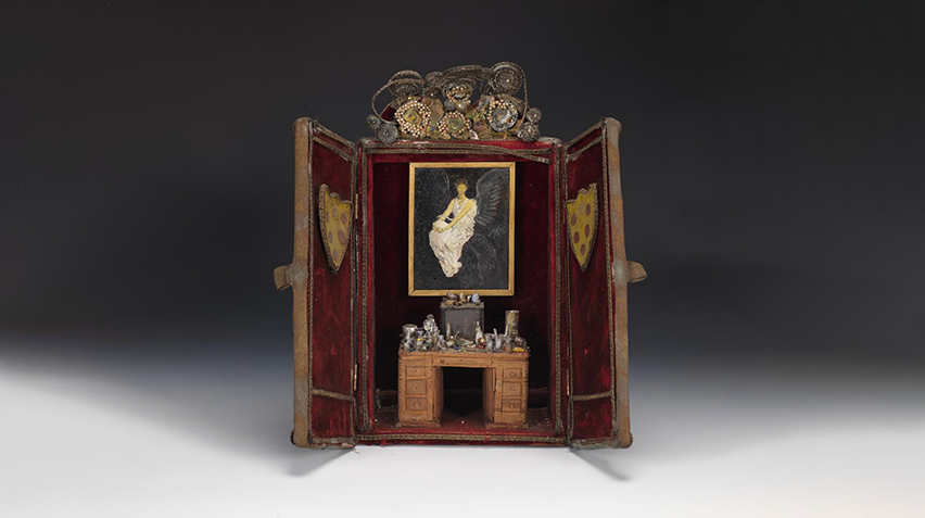 Diorama showing a miniaturized corner of a room with small paintings and glass