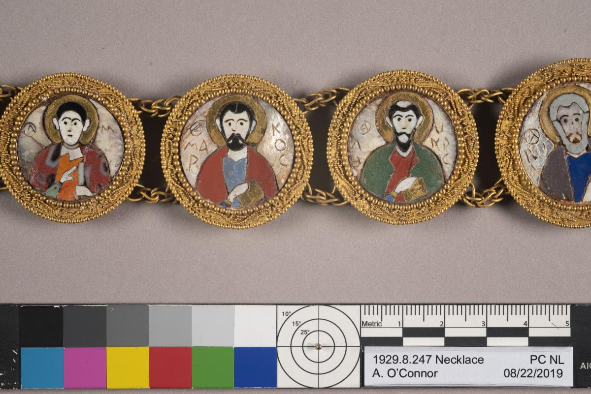 Four gold medallions with images that form part of a gold bracelet