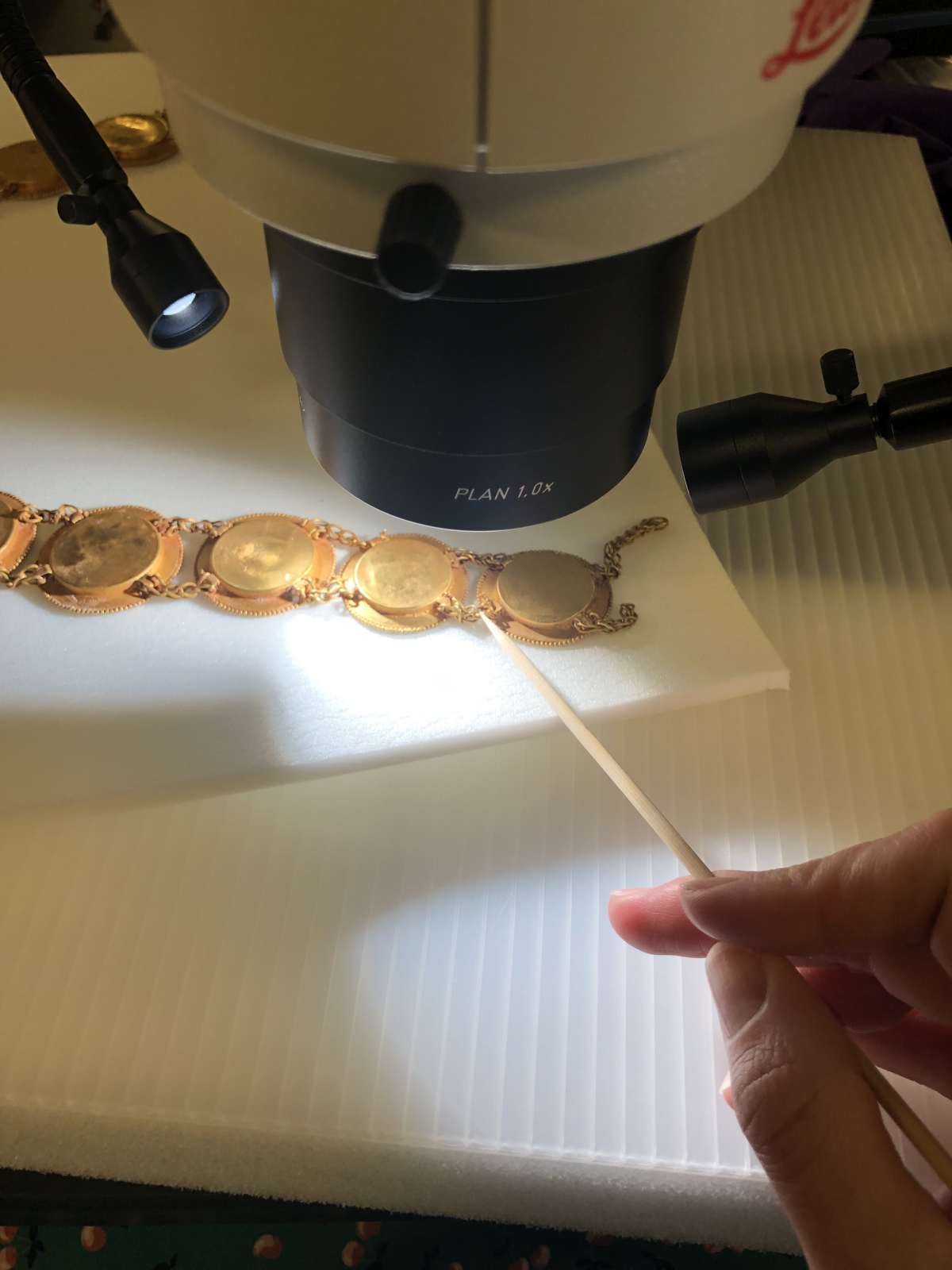 Examining reverse side of gold necklace