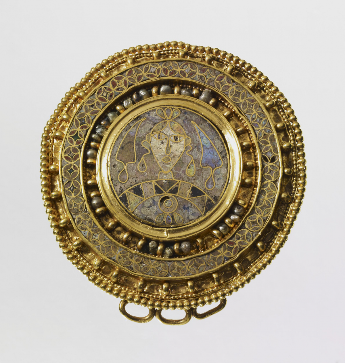A gold roundel with colorful enamel frames a portrait of a man