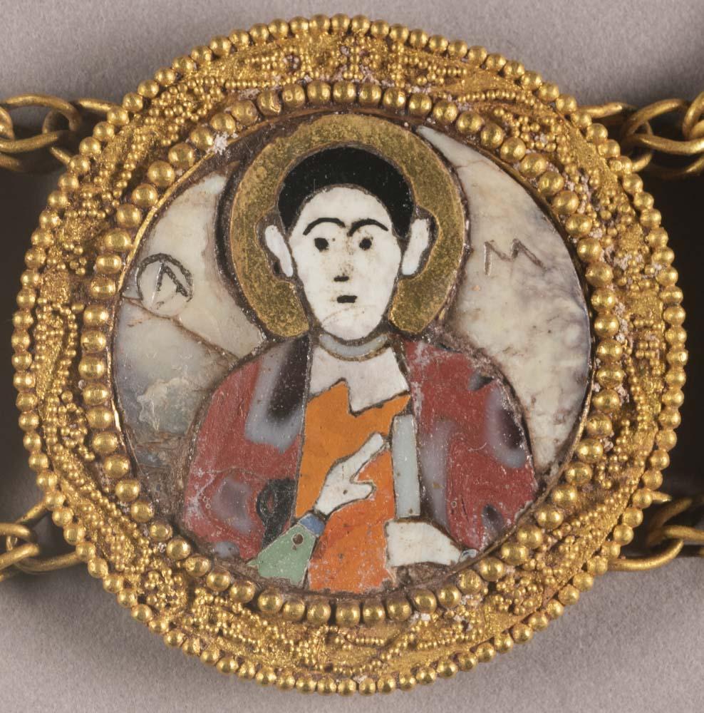a close-up of a glass and enamel portrait in a gold roundel