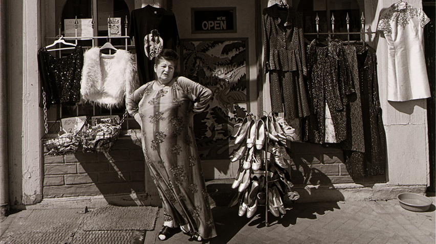 Blog - Elinor Cahn, Edith Massey, homepage A black and white photograph of Edith Massey standing in front of her store.
