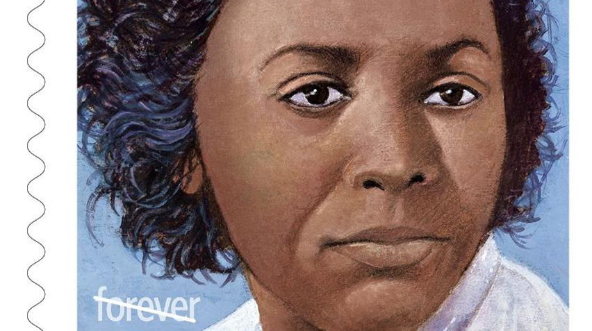 A close up of a woman of color's face on a stamp.