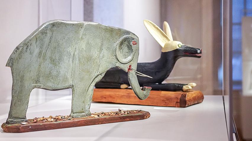 Two wooden sculptures, an elephant and a dog