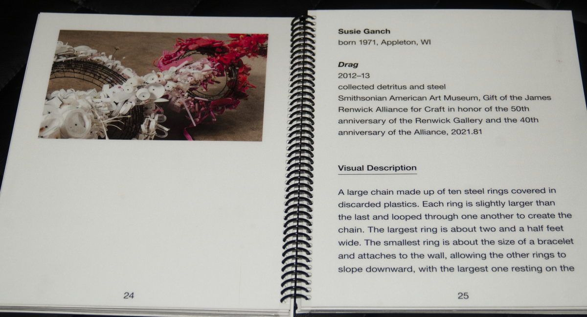 A binder showing an artwork with large print labels and verbal descriptions