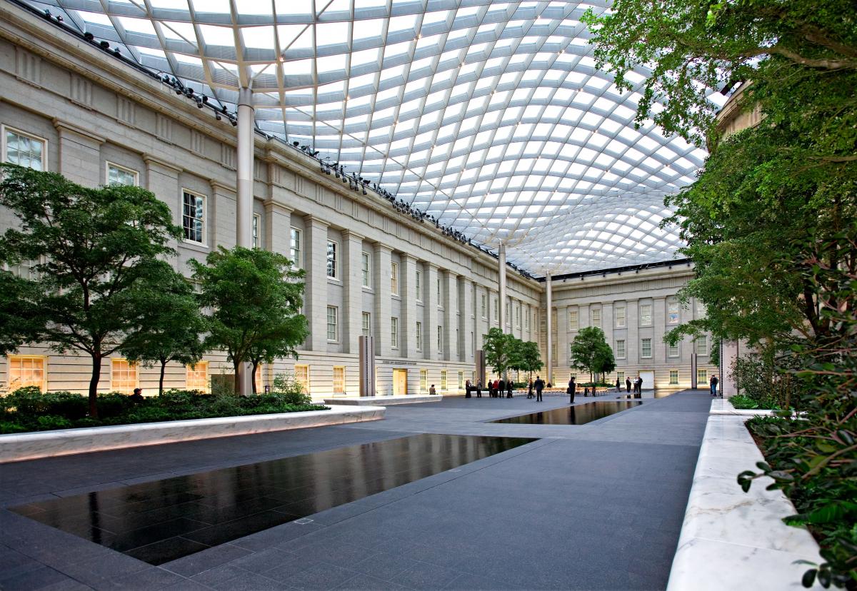 A wide shot of the Kogod Courtyard showing people and trees
