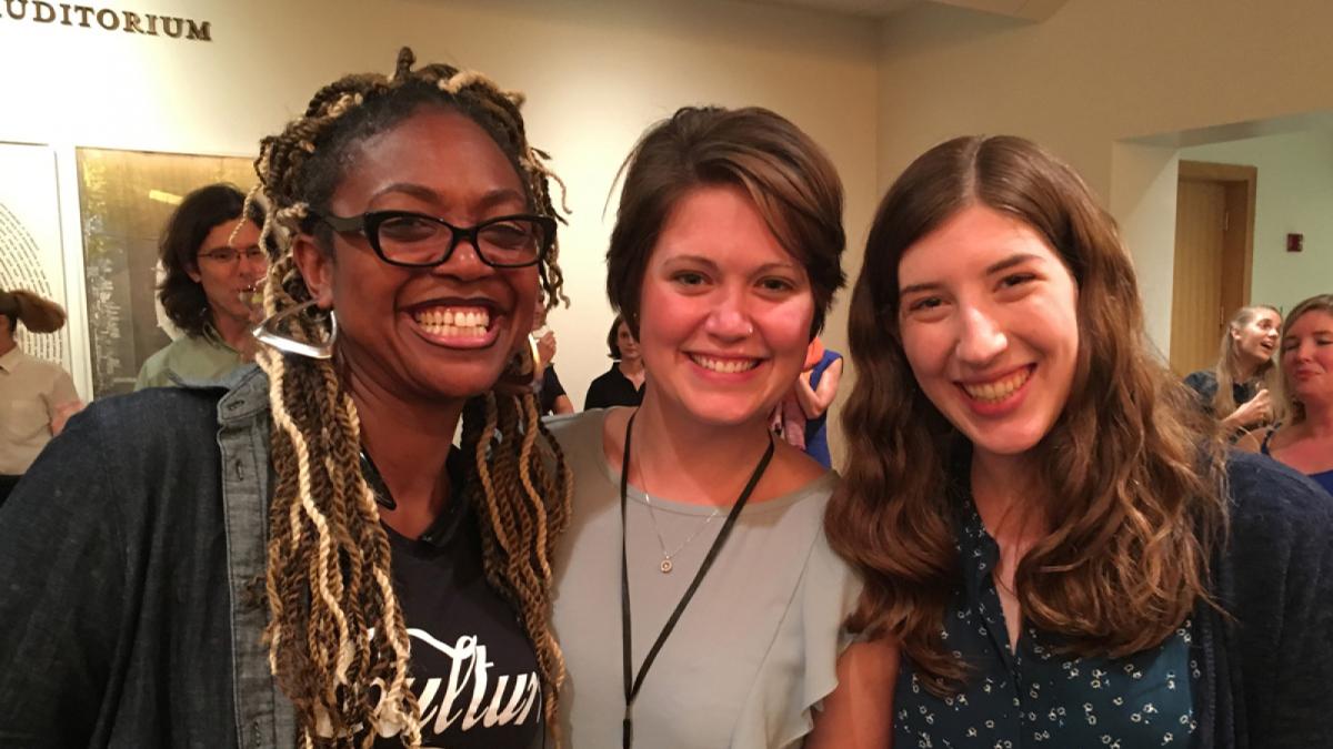 A group of three teachers smiles