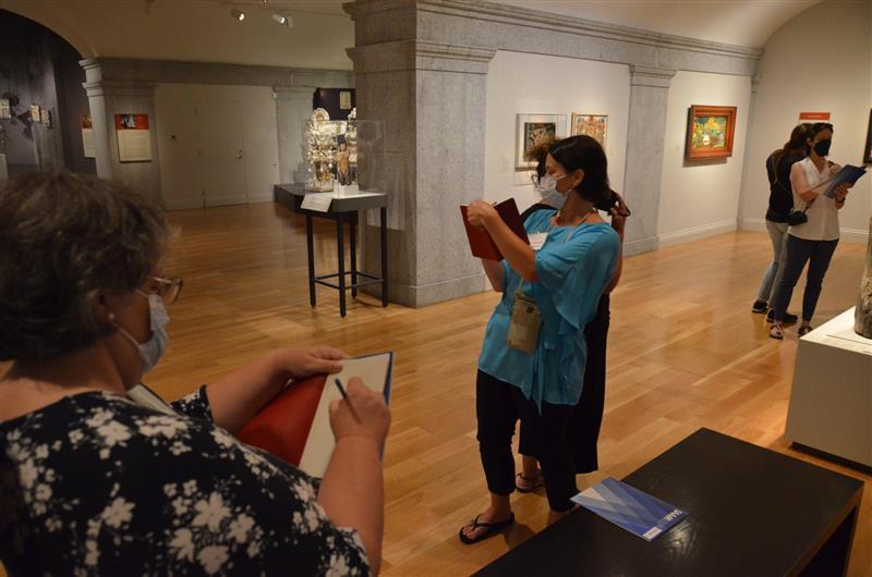 A group of educators take notes in the galleries.