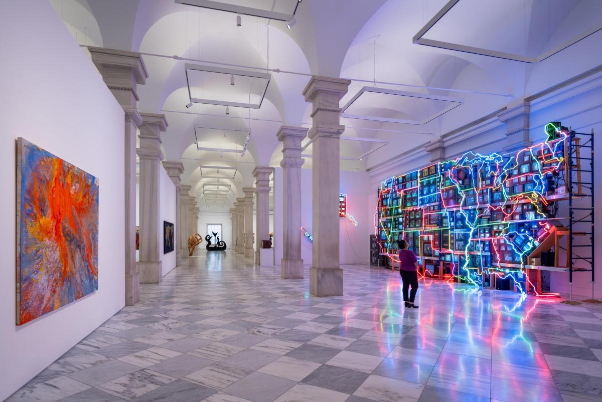 A marble gallery with a colorful neon sculpture of the United States and abstract painting