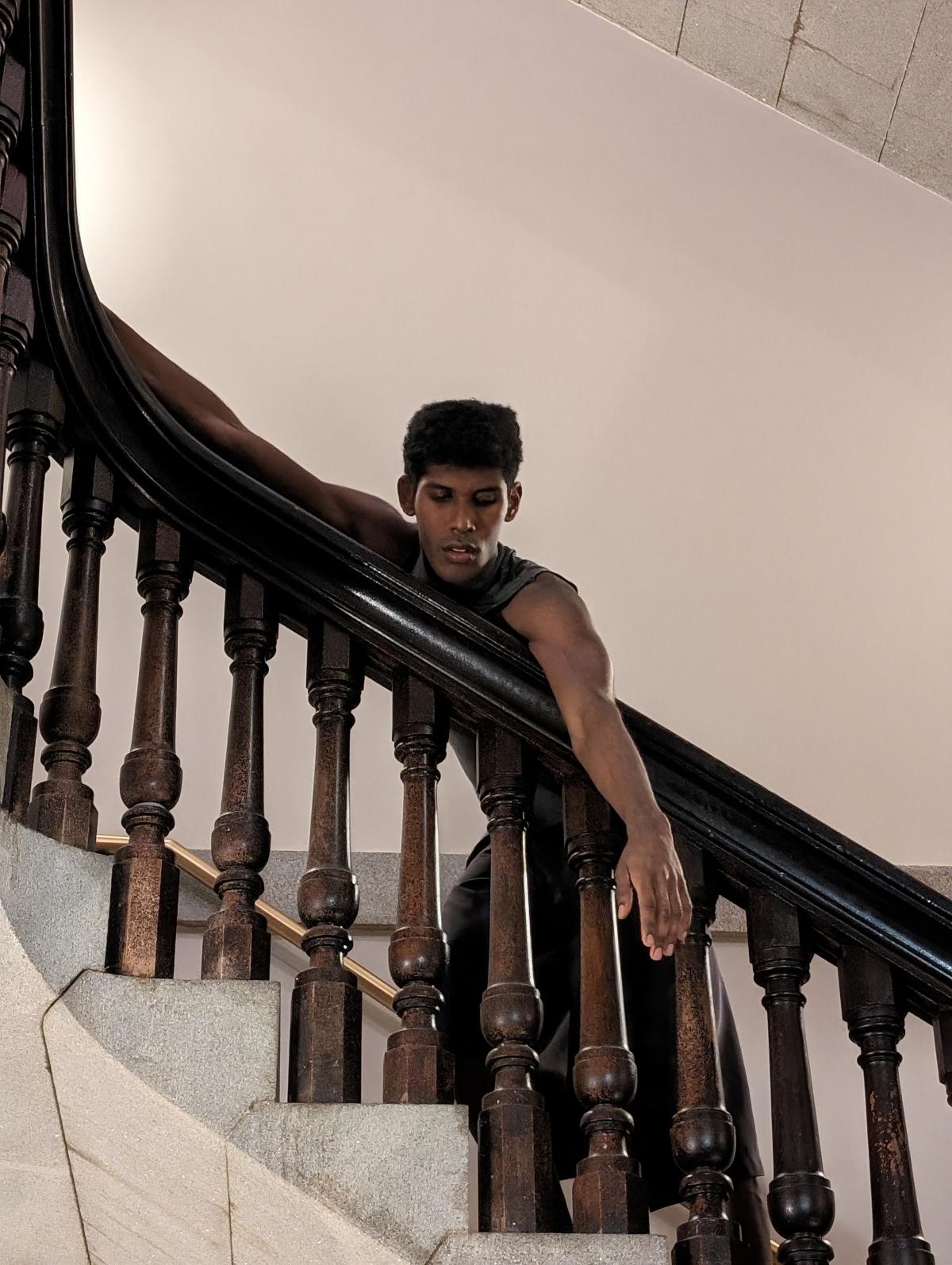 A dancer is draped on the rail in one of the Smithsonian American Art Museum's stairwells.