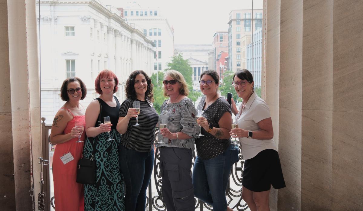 Six teachers pose for a photo against grand columns on SAAM's portico.